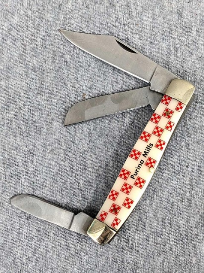 Purina Mills folding pocket knife, handle measures 4" long. Blade and handle slabs are tight.