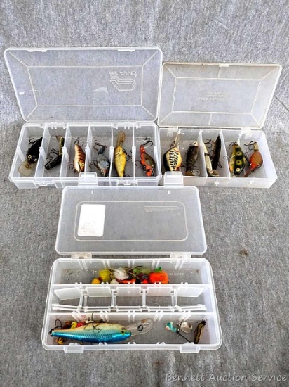 Three Plano and Flambeau fishing organizers with several styles of lures. Largest organizer is