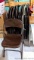 Set of 10 folding metal chairs. One oddball tan chair in a sea of brown.