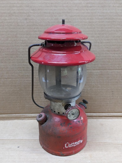 Coleman Model 200A red lantern with sunburst on the bottom and date code 8-64. Globe is broken.