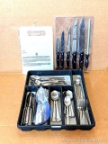 Silverware tray with flatware, plus a few extra pieces and a cutlery set.