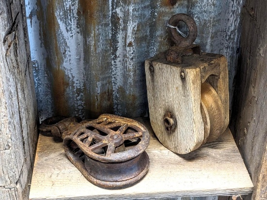 Two antique pulleys. Wooden pulley is unmarked and 9-1/2" overall; other pulley is marked M25A and