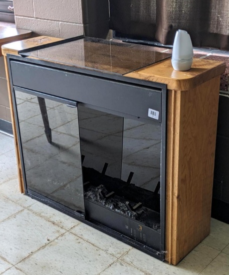 Electric fireplace-style heater, powered up when I plugged it in. Cabinet measures 40" wide x 31"