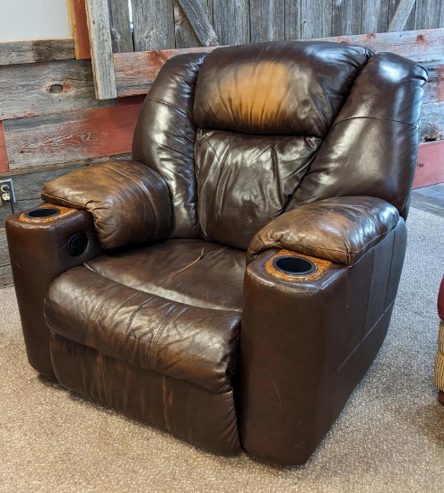 Oversized electric faux leather recliner with two cup holders and some where on head rest. Electric