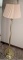 Brass toned floor lamp stands nearly 5'.