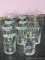 Guinness glasses - seven with green logo, four with gold logo.