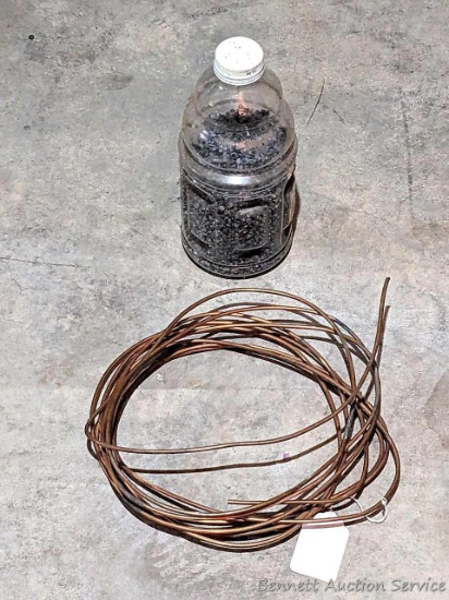 Jug about half full of lead pellets for melting down and a 8" coil of heavy copper wire.