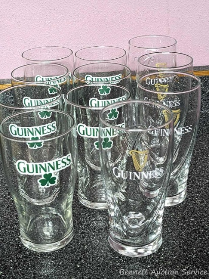 Guinness glasses - seven with green logo, four with gold logo.