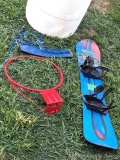 55 gallon poly barrel containing a snowboard, basketball hoop, and swing set components.