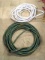 Two garden hoses, we're guessing the white one is 50' and the green one is 75'.
