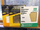 Three sandpaper packages, the 3M package has 220 grit paper, the other two packages have 0000 grade