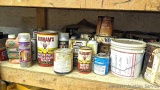 Durham's, Sherwin Williams and other paints and stains, some mostly full, some mostly empty.