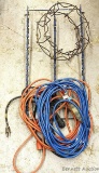 Two nice extension cords, one has lit ends, also comes with an extension cord reel and clip rack.