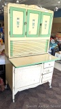 Vintage Hoosier cupboard with flour bin in upper cabinet and pie safe below and enamel counter;