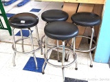 Four bar stools stand about 28