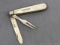 Antique fruit knife with a sterling silver blade and fork, mother of pearl handle slabs, and