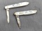 Two folding pocket knives with single and double blades, and mother of pear handles. The knives are