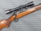 Winchester Model 70 Featherweight bolt action rifle chambered in .30-06 is topped with Weaver