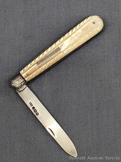 Antique fruit knife with a sterling silver blade, mother of pearl handle slabs, tooled bolster, and