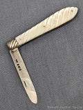 Antique fruit knife with a sterling silver blade, twisted looking mother of pearl handle slabs that