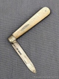 Antique fruit knife with a sterling silver blade, engraved mother of pearl handle slabs, and