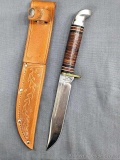 Western fixed blade knife with a tooled leather sheath. The knife is in very good condition with an