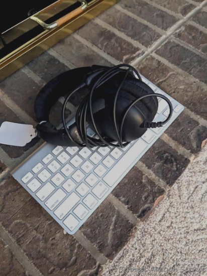 Corded Radio Shack padded ear headphones and small Apple cordless keyboard, Model #A1314 appears in