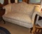 Upholstered love seat w/ exposed wood legs