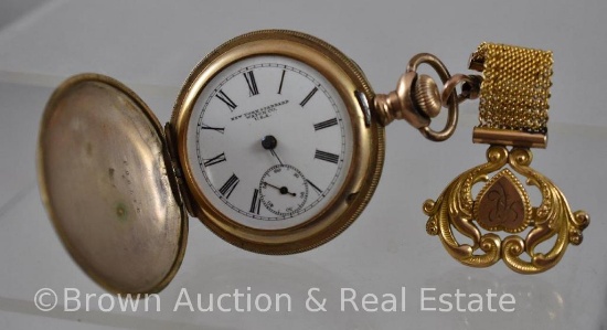 Gold New York Standard ladies pocket watch, embossed decorated closed case with lapel pin fob