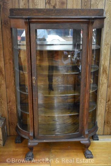 Curved glass china cabinet with large paw feet