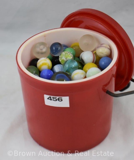 Red plastic Thermal picnic jar full of assorted marbles