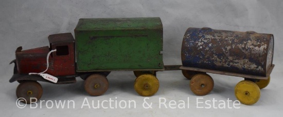 Vintage pressed steel truck with detachable cargo trailer pulling oil/water tank