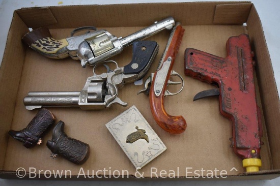 Assortment of (4) toy guns, western belt buckle and cowboy boots salt and pepper set