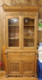 Oak kitchen cupboard, glass front top and storage below, carved application and top