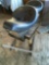 Motorcycle seat on wood stand. (Gazebo area)