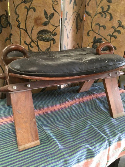 Vintage camel saddle. Wood frame with flower designs and leather seat. Approx. 17" x 30" x 15"