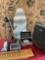 Assorted items. Luggage, iron board, iron, boxes, tripod, All electrical items turned on. 8 pieces