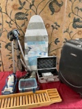 Assorted items. Luggage, iron board, iron, boxes, tripod, All electrical items turned on. 8 pieces