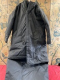Black, insolated , hoodie, pockets coat that converts into sleeping bag. Seems to be a L/ XL