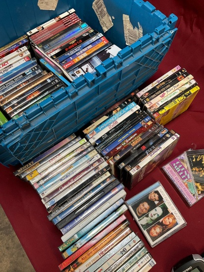 Assorted DVDs and CDs. Over 80 pieces includes storage tub