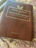 Golden Replica of Unites States stamps album with replicas on a gleaming surface 22kt gold & other