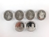 Group of six silver clad Morgan dollars and commemorative 911 dollar.