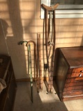 Group of vintage crutches, Canes, and flagpoles