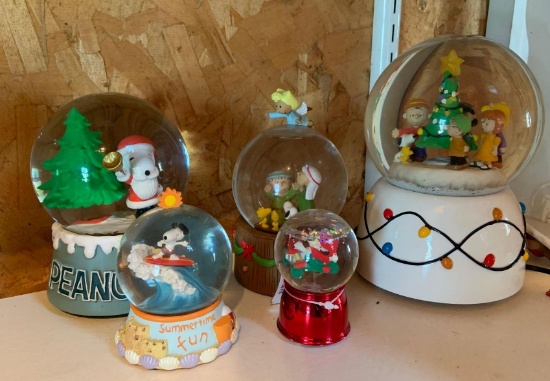Group of five Peanuts snow globes