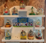 Group of peanuts holiday snow globes with display rack