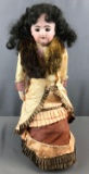 Antique doll on stand, black hair and brown eyes