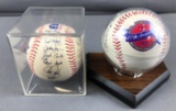 Group of 2 autographed baseballs in display cases