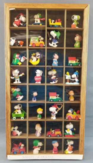 Peanuts figures, vehicles and more in display case