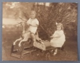 Vintage photograph of children riding on toy horse and car