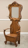 Fancy antique oak Lift Seat Hall Tree, circa 1900-1910, with beveled glass mirror and four coat and
